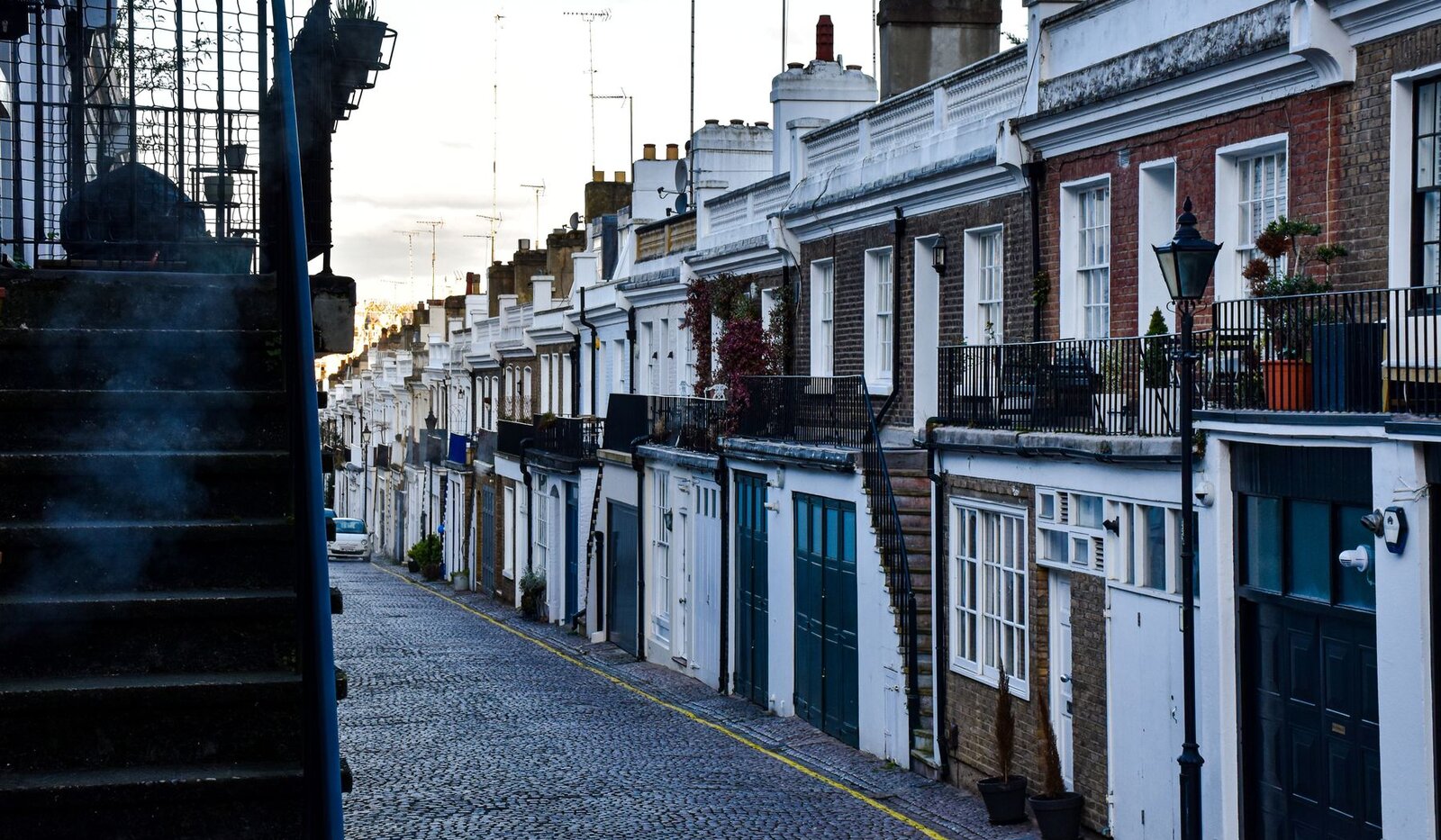 A quiet cobbled London street lined with traditional homes