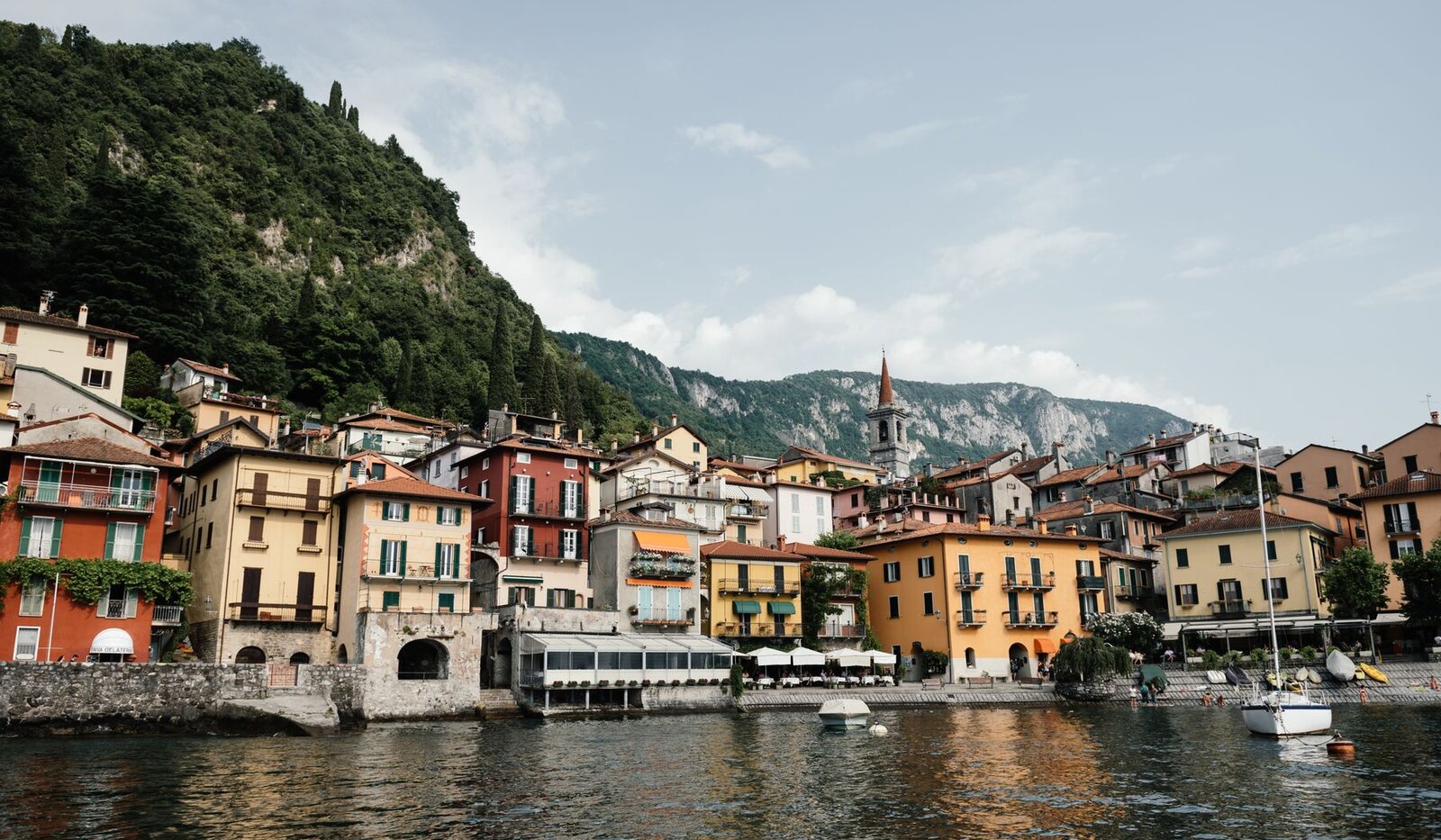 Colourful waterfront buildings in Varenna beside Lake Como, with mountains in the background