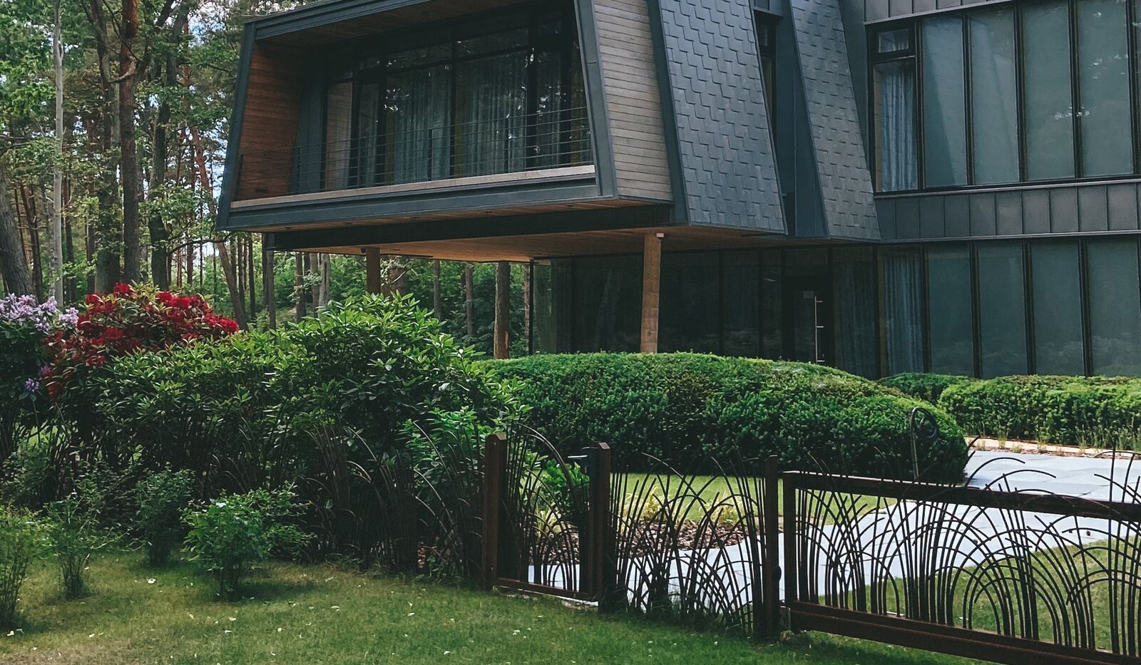 Contemporary dark-clad home surrounded by a leafy garden