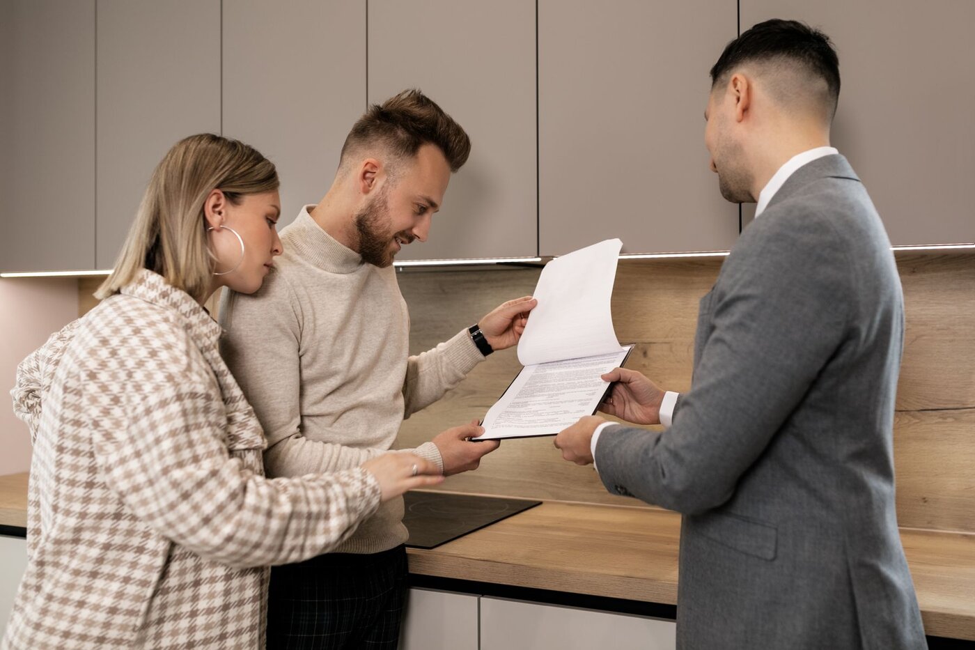 Buyers discussing property documents with an adviser; an illustrative photograph