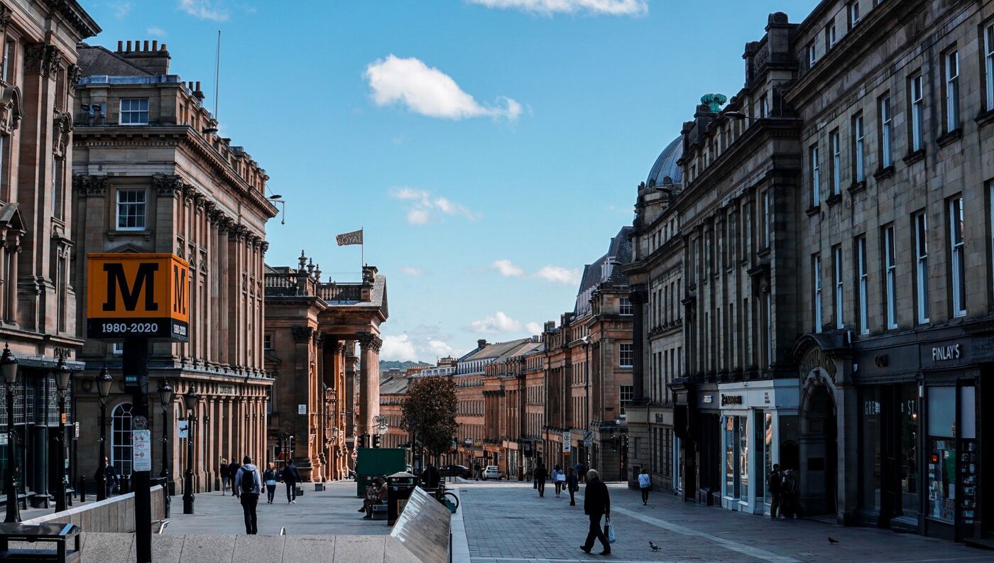 A sunlit Edinburgh street with historic stone buildings