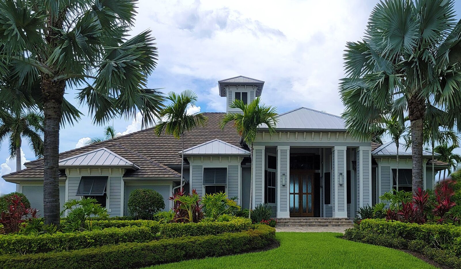 Detached home framed by palm trees and a landscaped garden